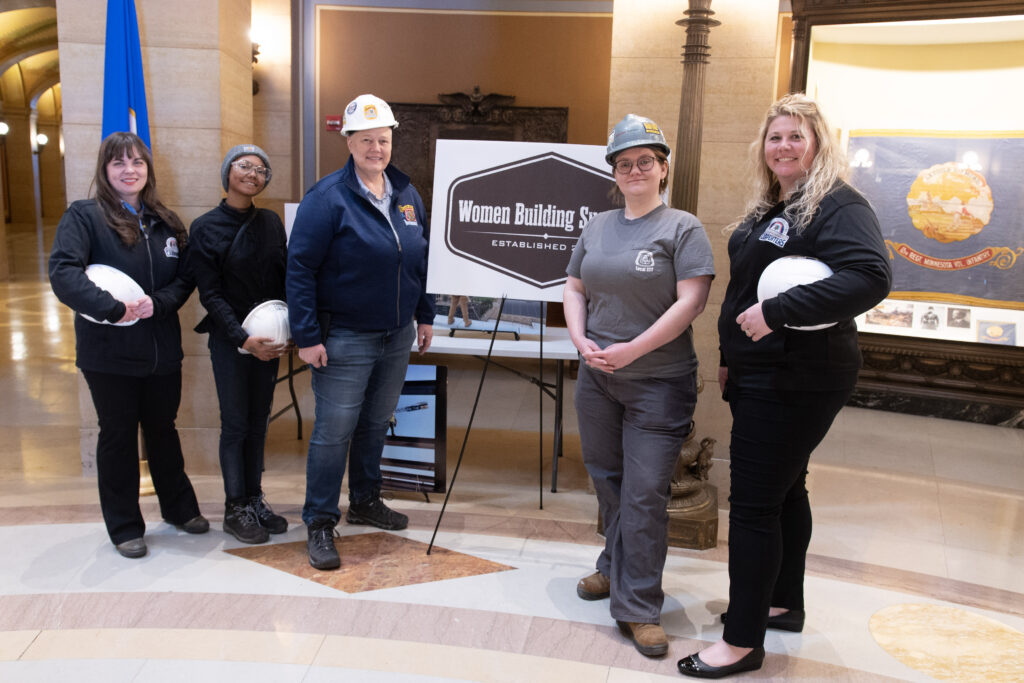 People stopped to look at the prints that lined the Minnesota State Capitol rotunda in early March, past winners of the Women in Construction Week Photo Contest, just one of the events that recognized women in construction.